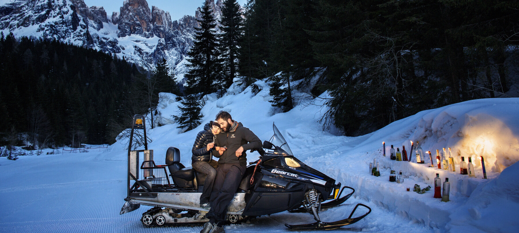 Enjoy an apéritif while admiring the Dolomites after a fun snowmobile ride 