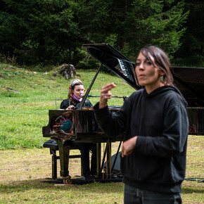 While the artist sings accompanied by the piano, the LIS interpreter translates the lyrics of the song in sign language.