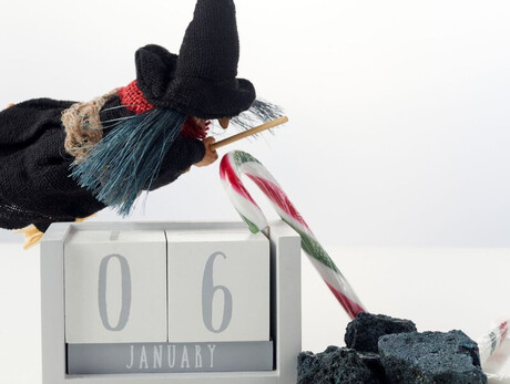 Nella foto si vede un pupazzetto della befana con carbone e caramelle e un calendario che indica il 6 di gennaio