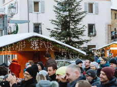 Piazza piena di persone che festeggiano durante le feste natalizie con concerti e casette di prodotti tipici