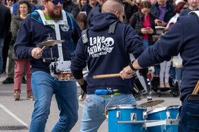 GRUPPE VON TROMMLERN MIT VIELEN ZUSCHAUERN UM SICH HERUM, DIE ZUSCHAUEN UND ZUHÖREN