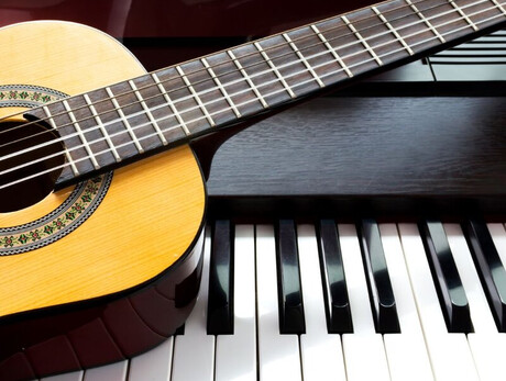 Nell'immagine si vedono una pianola e una chitarra