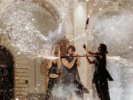 Image of three artists performing a show with fire