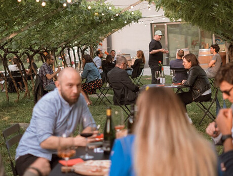 Persone nel vigneto che si rilassano degustando vini dell'azienda