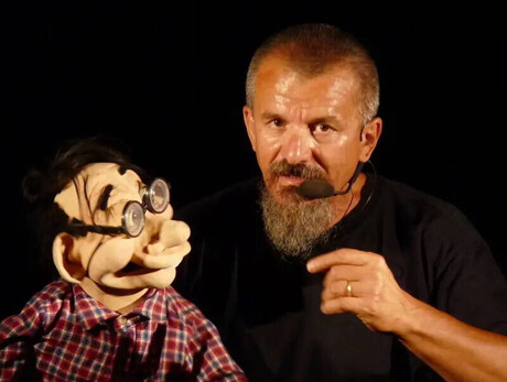 L'immagine mostra Cigarini il ventriloquo durante un suo spettacolo mentre parla con un pupazzo
