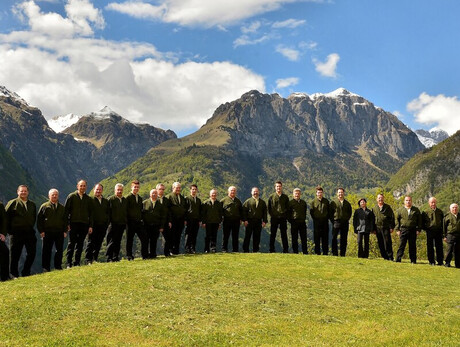 L'immagine mostra i componenti del coro cima Ambiez; sullo sfondo la maestosa cima da cui il coro prende il nome