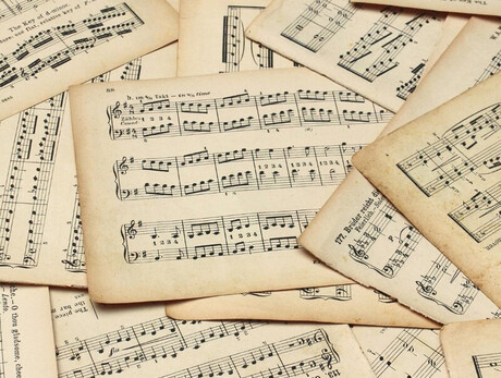 Nell'immagine si vedono molti spartiti su un tavolo