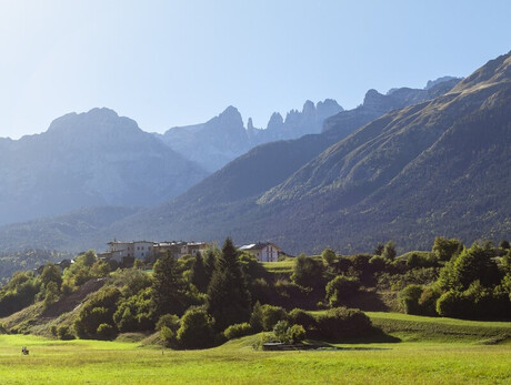 Una foto di Andalo in estate dove si vede il maso Monego e sullo sfondo leDolomiti di Brenta