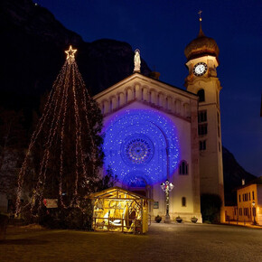 Piazza centrale del paese, con la Chiesa illumninata, l'albero di Natale e il presepe