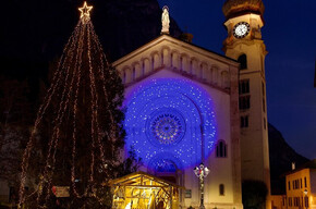 Piazza centrale del paese, con la Chiesa illumninata, l'albero di Natale e il presepe