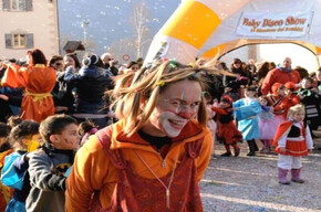 UN SIMPATICO CLOWN CHE GIOCA CON I BAMBINI IN PIAZZA CON CORIANDOLI E STELLE FILANTI