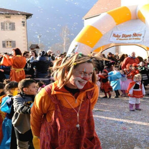 UN SIMPATICO CLOWN CHE GIOCA CON I BAMBINI IN PIAZZA CON CORIANDOLI E STELLE FILANTI