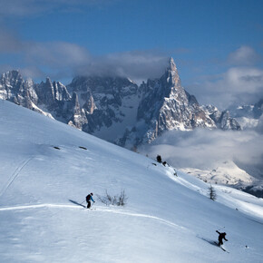 sciatori fuoripista a Bellamonte, con vista sulle Pale di San Martino