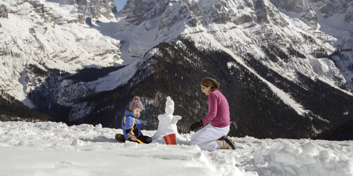 Madonna di Campiglio - Mamma con bambina fanno un pupazzo di neve