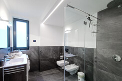 Badezimmer mit Glasdusche und Waschmaschine