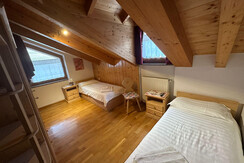 Podkrovní pokoj s postelemi a okny