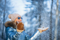 woman-blowing-snow-from-gloves