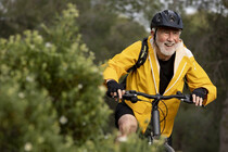 portrait-senior-man-with-bike-on-mountain